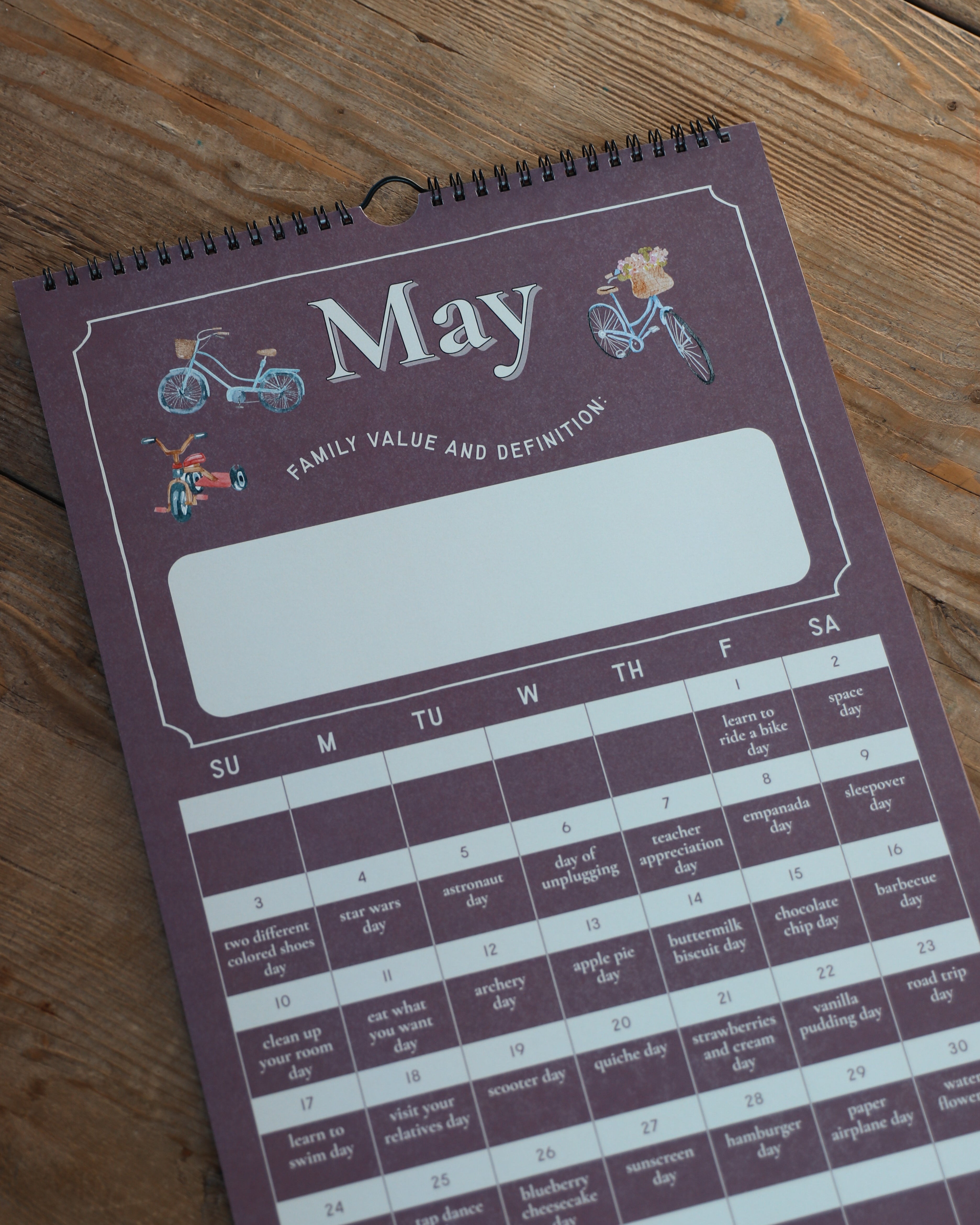 Purple calendar for May on a wooden surface