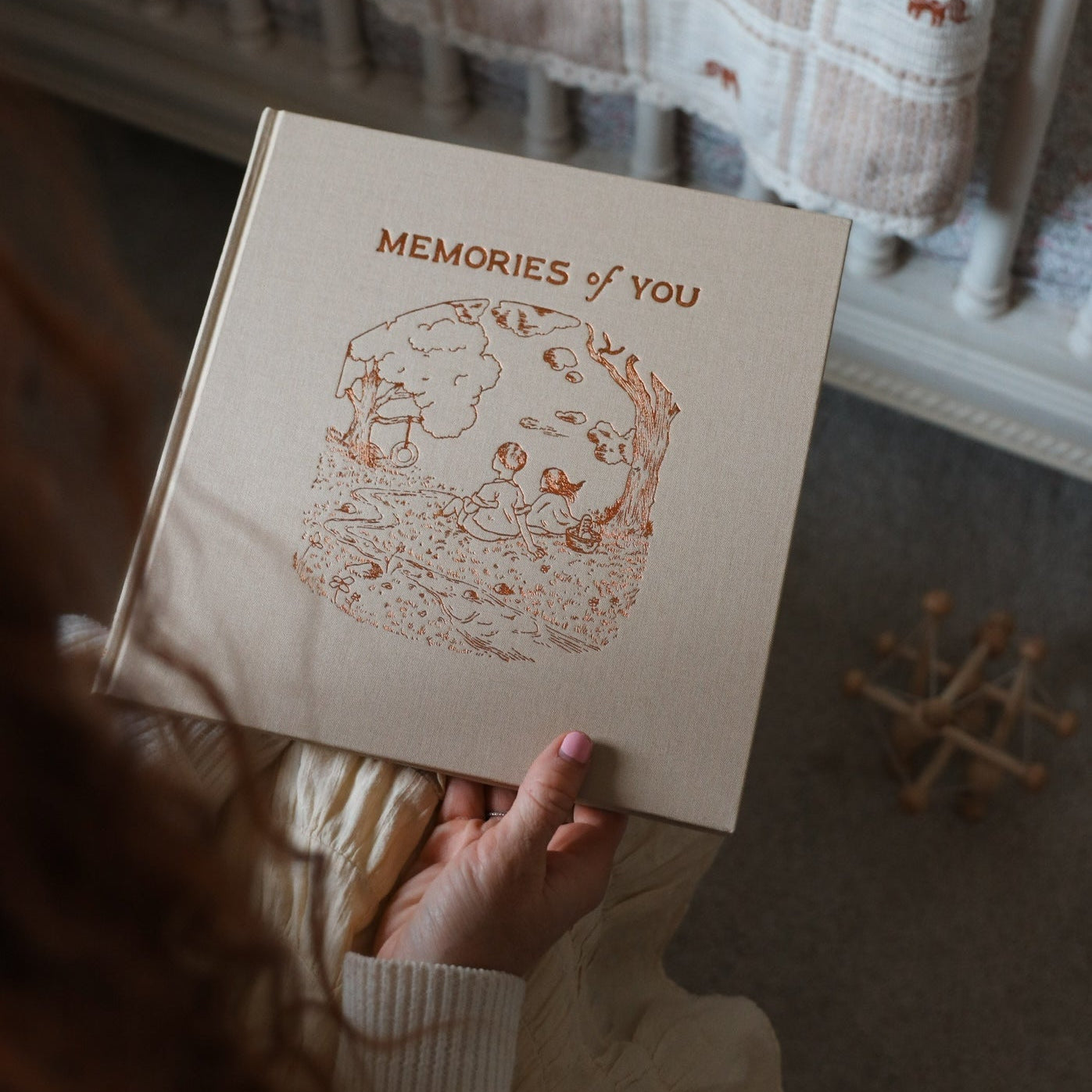 Hand holding a book titled 'Memories of You' with a decorative cover.